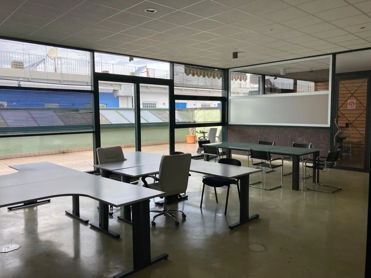 Open space con postazioni di lavoro e vetrate sul terrazzo